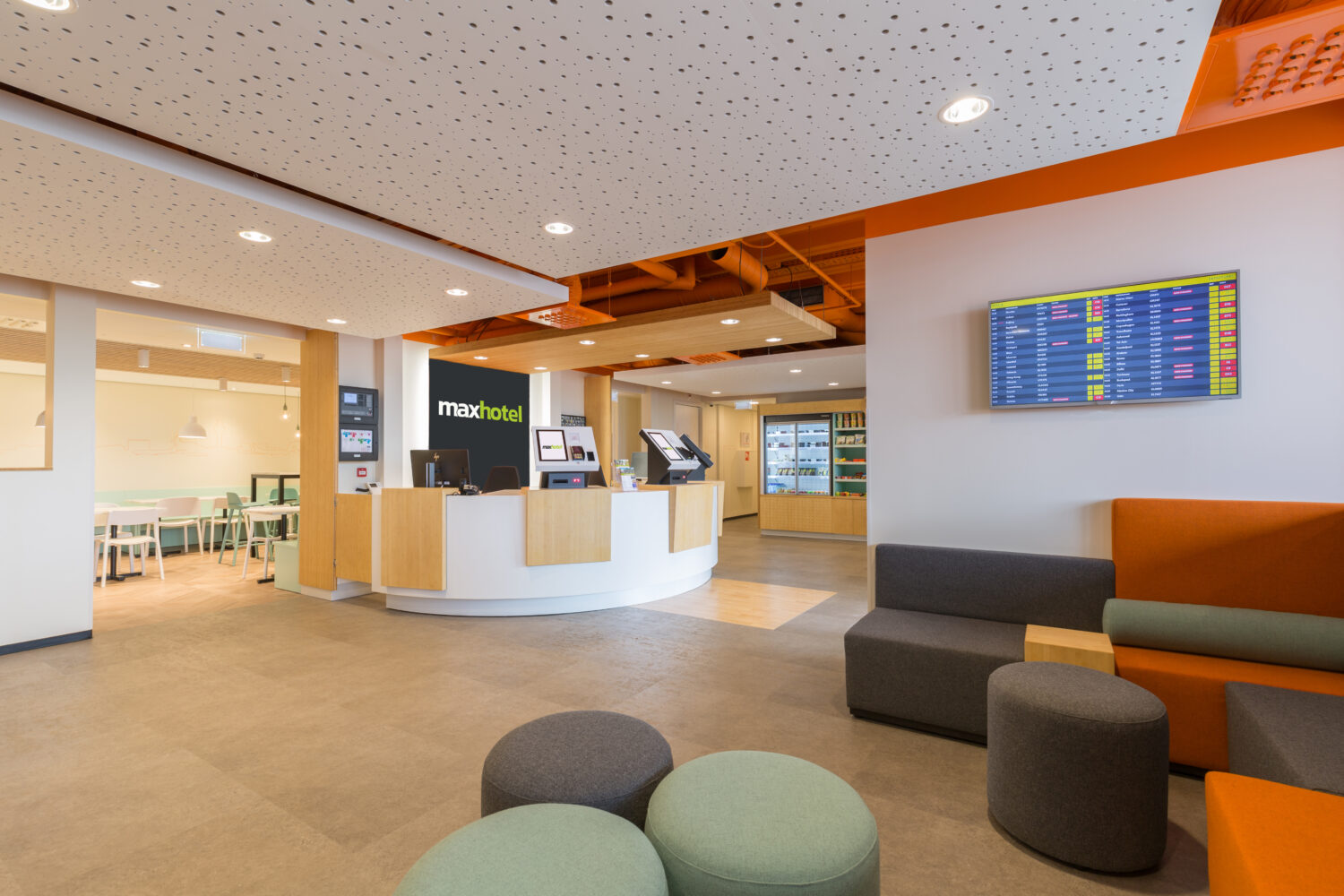 Hotel Entrance with many seating areas and a screen of departures at the airport