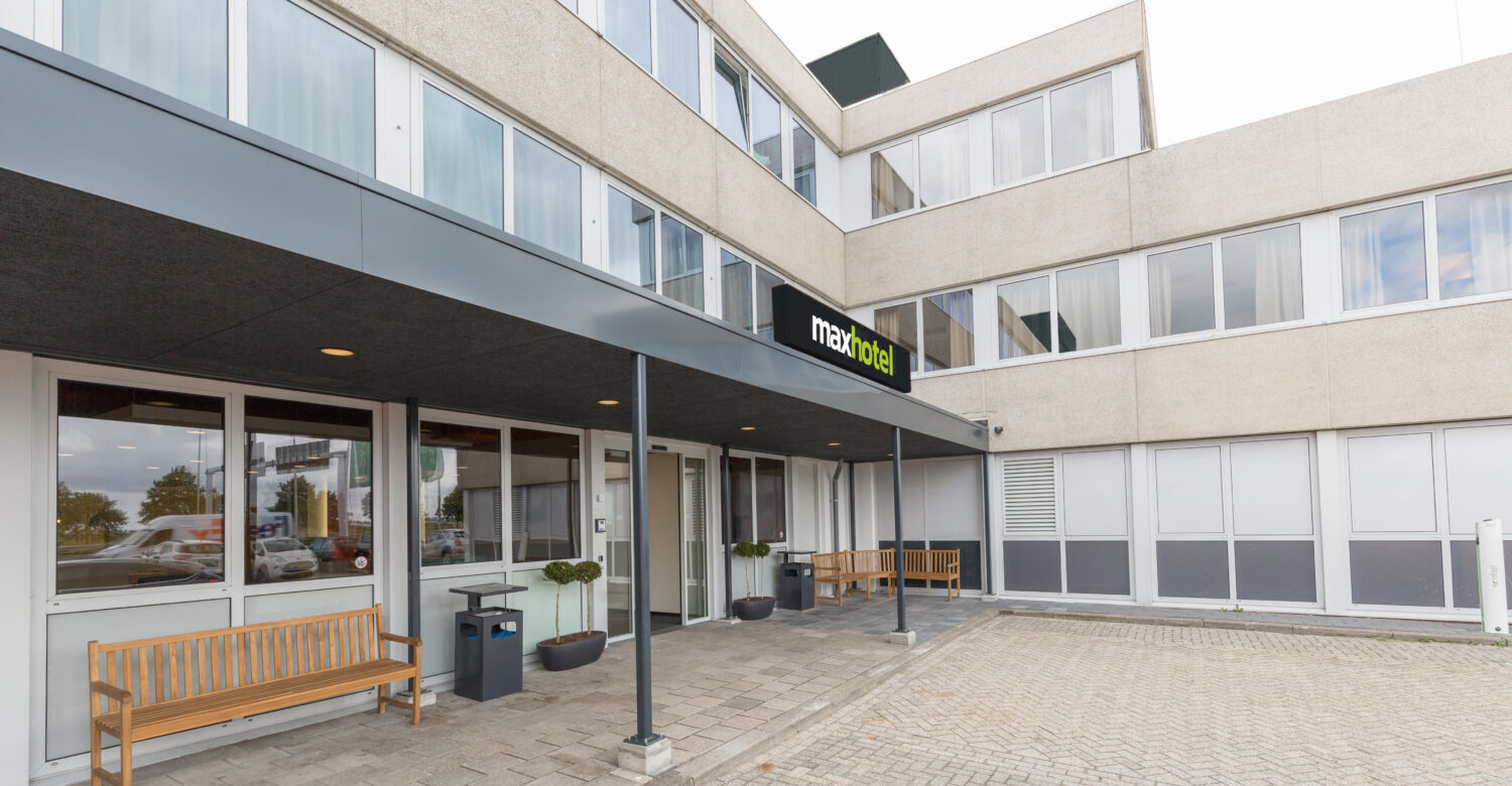 Outside view of the Maxhotel with a few benches and plants