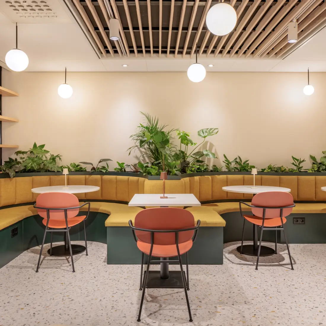 Moderne Maxhotel lounge met gebogen stoelen, duurzame planten en werktafels voor het comfort van de gasten
